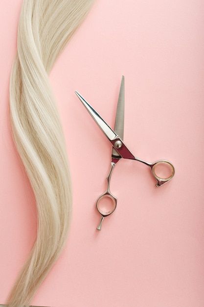 Premium Photo | Flat lay composition with hairdresser tools – scissors and strand of blonde hair on pink color background with copy space for text. hairdresser service. beauty salon service.